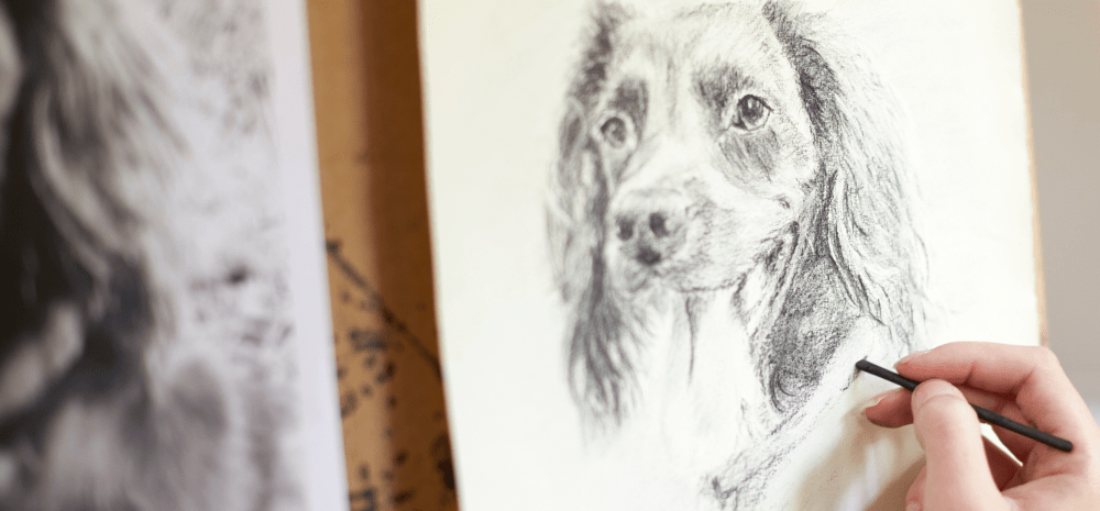 A person drawing a dog on paper.