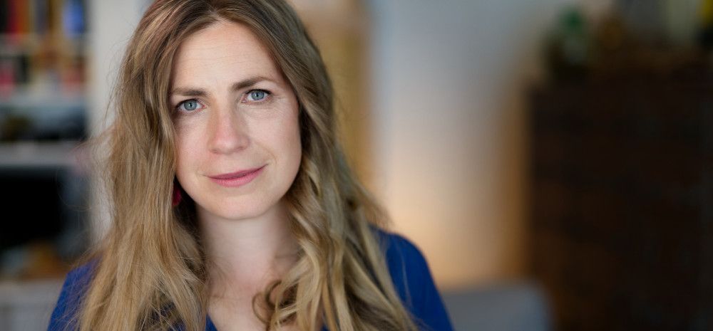 Author Kate Solly in front of a bookshelf. 