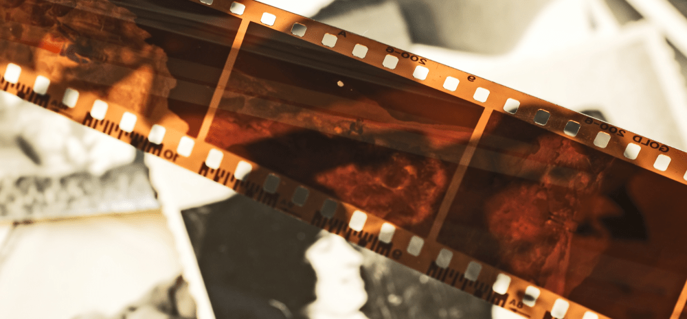 A photo film roll negatives viewed over the background of the black and white photos.
