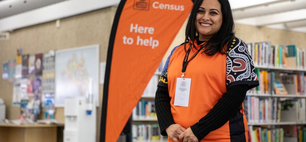 Official standing next to a census help sign.