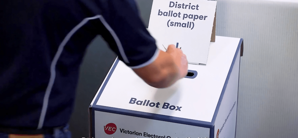 Victorian State Election Ballot box with a person placing their ballot in the slot.
