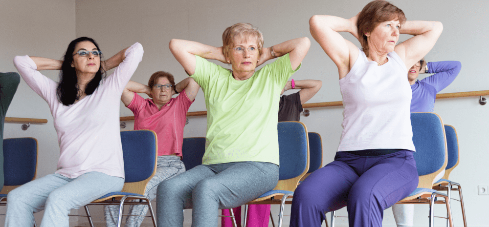 Older adults participating in a seated chair yoga class.