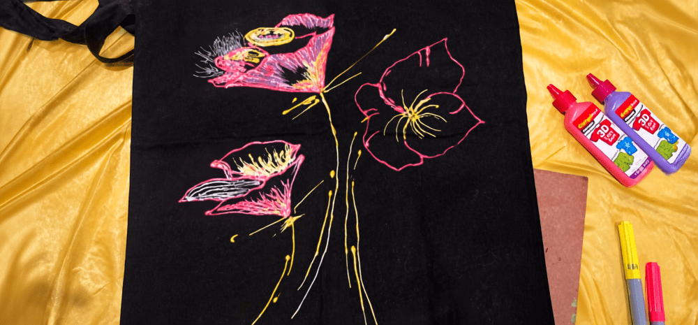 A colourful image depicting three flowers painted on black fabric.