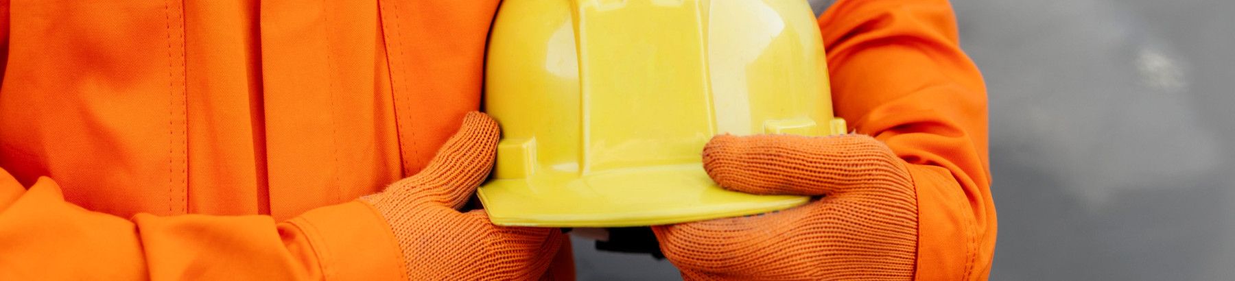 Closeup of construction worker holding a hard hat.