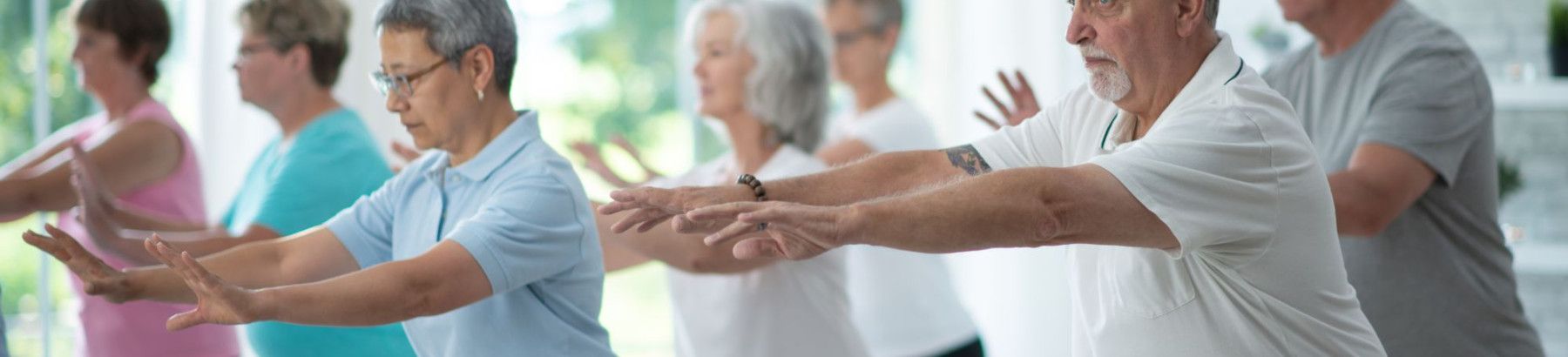 Seniors in an exercise class with arms outstretched