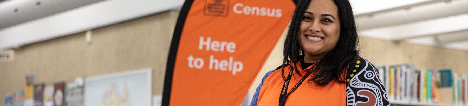 Official standing next to a sign about Census help.