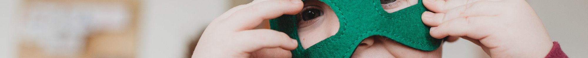 Image: a child wearing a green mask on his eyes