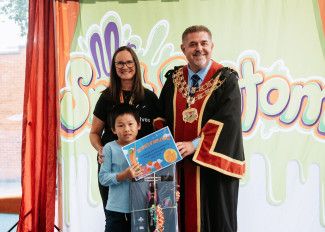 Mayor Cr Jim Memeti and Library Services Senior Coordinator Monique Godbehere present the prize to the lucky winner of the BIG Summer Read.