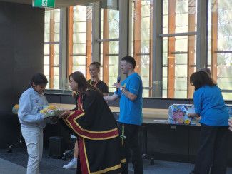 Mayor Sophie Tan presents a prize to a participant in the BIG Summer Read, with library staff.