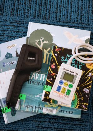 Books and various gadgets from library collection laid out on carpet.