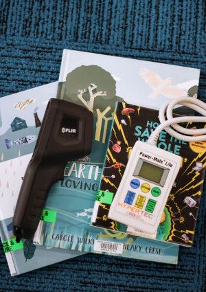 Thermometer, thermal imaging camera and Power Mate Lite devices arranged on library books.